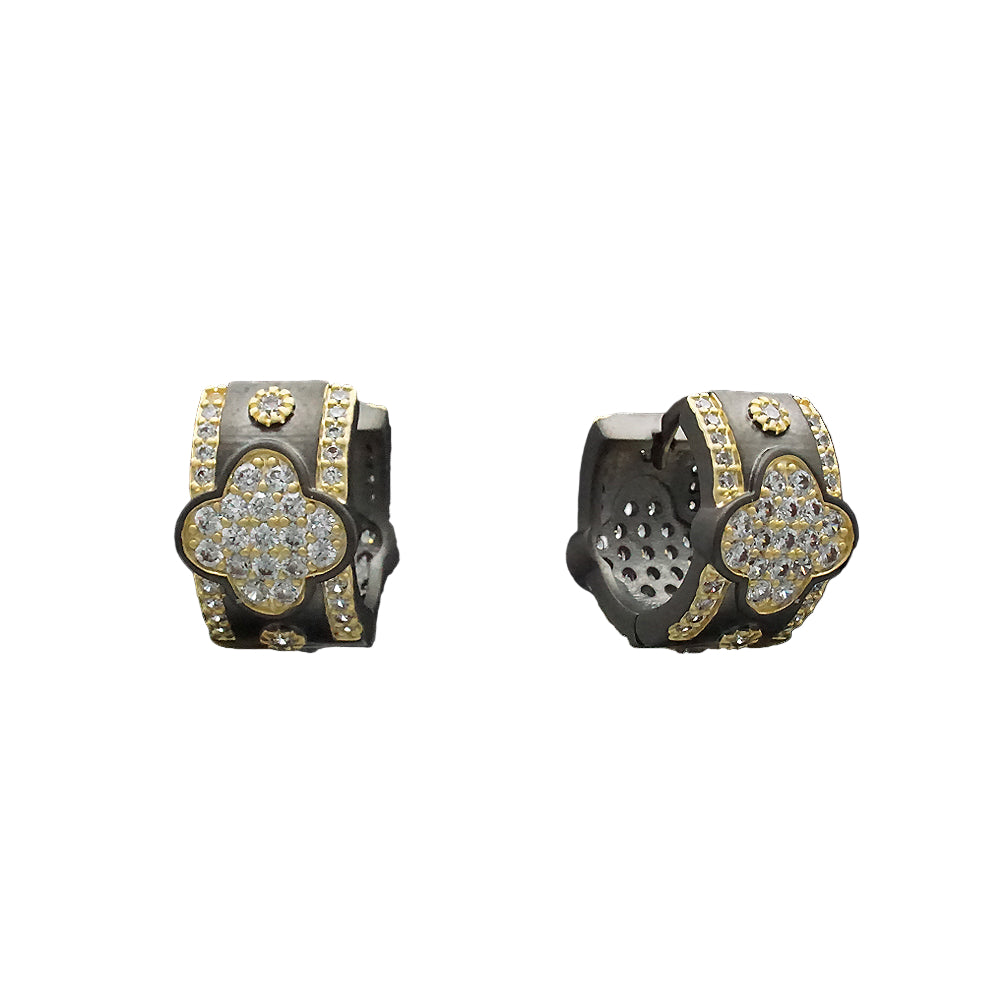Pair of gold and black earrings on a black background
