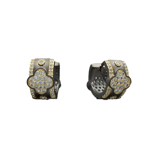 Pair of gold and black earrings on a black background